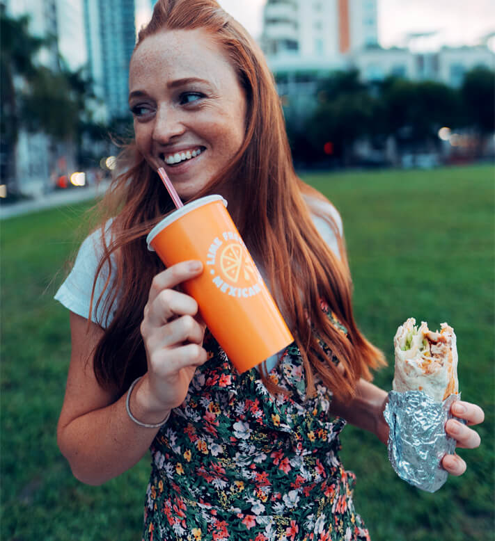 Miami girl posing with LIME Fresh Mexican Grill burrito and drink